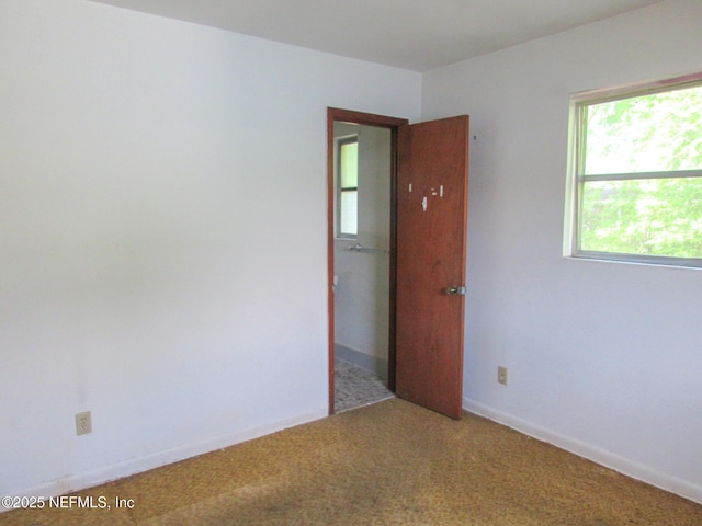 empty room featuring carpet floors and baseboards
