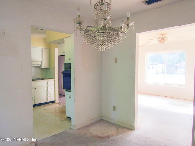 interior space featuring baseboards, a notable chandelier, and light carpet