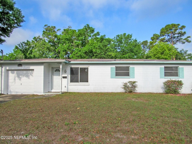 view of front of property with an attached garage, concrete block siding, and a front lawn