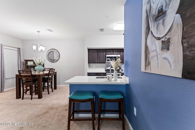 4958 Key Lime Dr Unit 106, Jacksonville, FL 32256 - kitchen with a sink, a chandelier, a breakfast bar, hanging light fixtures, and dark brown cabinets