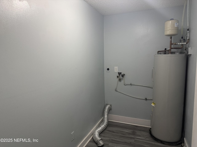 6070 Baltimore Ave, Cocoa, FL 32927 - laundry area featuring electric dryer hookup, electric water heater, wood finished floors, baseboards, and a textured ceiling