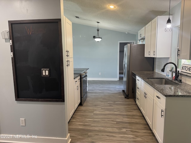 6070 Baltimore Ave, Cocoa, FL 32927 - kitchen with range with electric cooktop, a sink, vaulted ceiling, white cabinets, and a textured ceiling