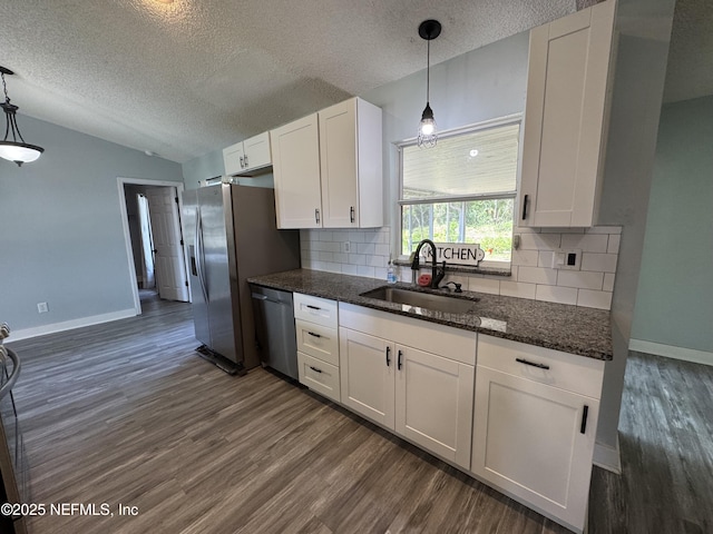 6070 Baltimore Ave, Cocoa, FL 32927 - kitchen with stainless steel appliances, a sink, a textured ceiling, dark wood-type flooring, and tasteful backsplash