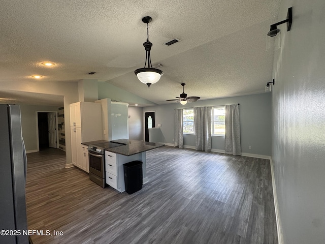 6070 Baltimore Ave, Cocoa, FL 32927 - kitchen featuring appliances with stainless steel finishes, a textured ceiling, open floor plan, dark countertops, and dark wood-type flooring