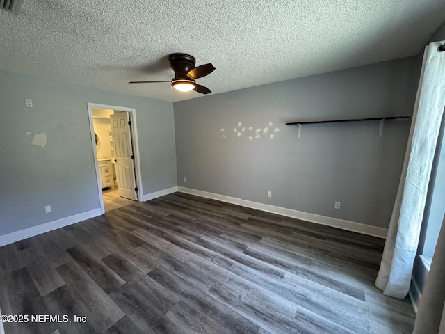 6070 Baltimore Ave, Cocoa, FL 32927 - unfurnished bedroom with dark wood-style floors, a textured ceiling, baseboards, connected bathroom, and a ceiling fan