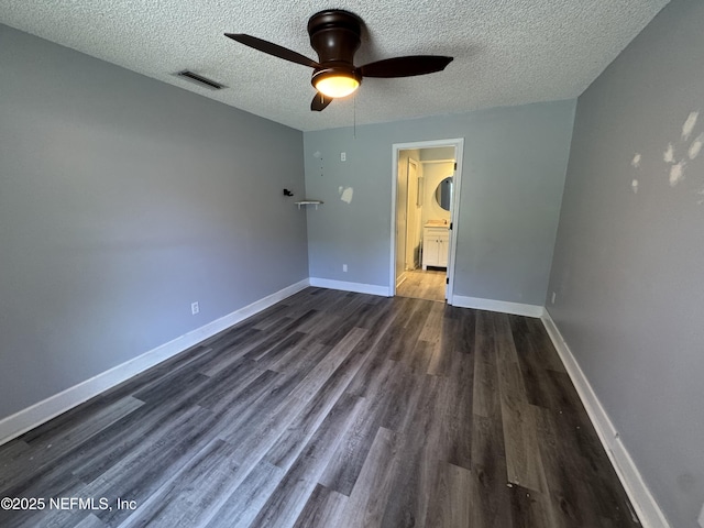 6070 Baltimore Ave, Cocoa, FL 32927 - unfurnished bedroom with a textured ceiling, dark wood-type flooring, a ceiling fan, baseboards, and ensuite bath