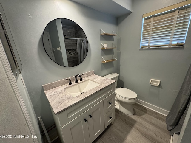 6070 Baltimore Ave, Cocoa, FL 32927 - bathroom featuring wood finished floors, toilet, vanity, baseboards, and curtained shower