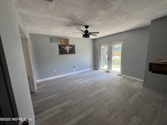 6070 Baltimore Ave, Cocoa, FL 32927 - unfurnished living room featuring ceiling fan, wood finished floors, a textured ceiling, and baseboards