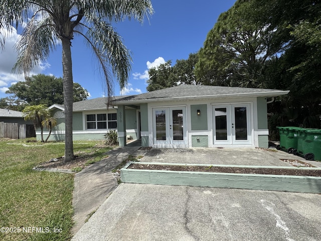 6070 Baltimore Ave, Cocoa, FL 32927 - view of front of house with french doors, stucco siding, and a front lawn