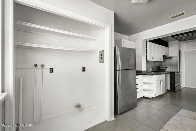 8384 Delaware Ave, Jacksonville, FL 32208 - clothes washing area featuring baseboards and dark tile patterned flooring