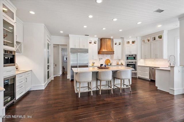 301 S Roscoe Blvd, Ponte Vedra Beach, FL 32082 - kitchen featuring appliances with stainless steel finishes, a breakfast bar, beverage cooler, recessed lighting, and custom exhaust hood