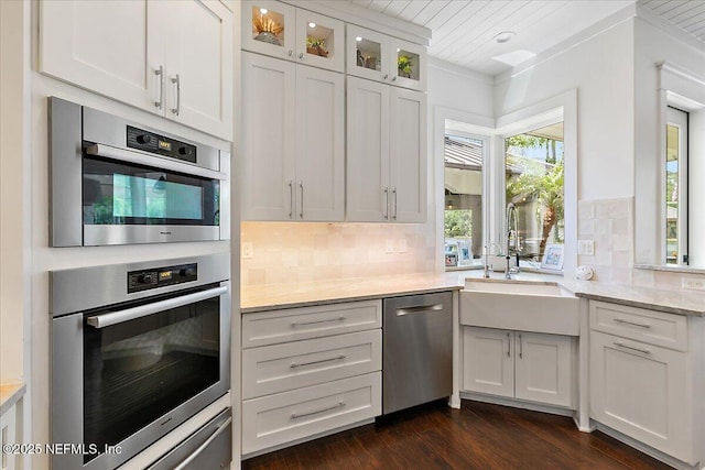 301 S Roscoe Blvd, Ponte Vedra Beach, FL 32082 - kitchen with stainless steel dishwasher, decorative backsplash, dark wood-style floors, white cabinetry, and a sink