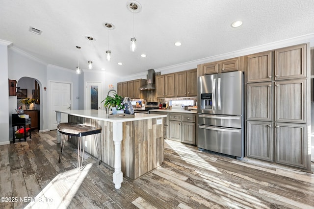1417 Marlee Rd, Saint Johns, FL 32259 - kitchen featuring stainless steel appliances, wall chimney exhaust hood, ornamental molding, wood finished floors, and a kitchen island with sink