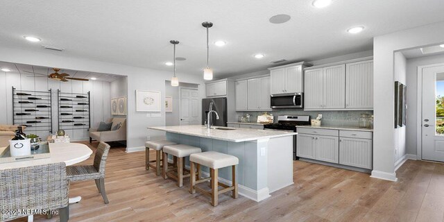 166 Whistling Straits Dr, Saint Johns, FL 32259 - kitchen with decorative backsplash, stainless steel appliances, a kitchen bar, baseboards, and an island with sink