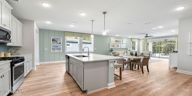 166 Whistling Straits Dr, Saint Johns, FL 32259 - kitchen featuring light wood-style flooring, stainless steel appliances, decorative light fixtures, ceiling fan, and a sink