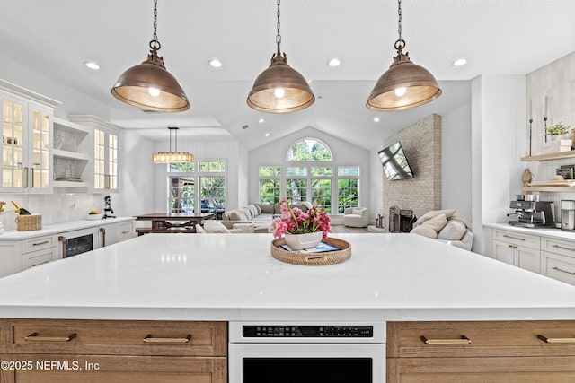 kitchen featuring light countertops, open shelves, and open floor plan