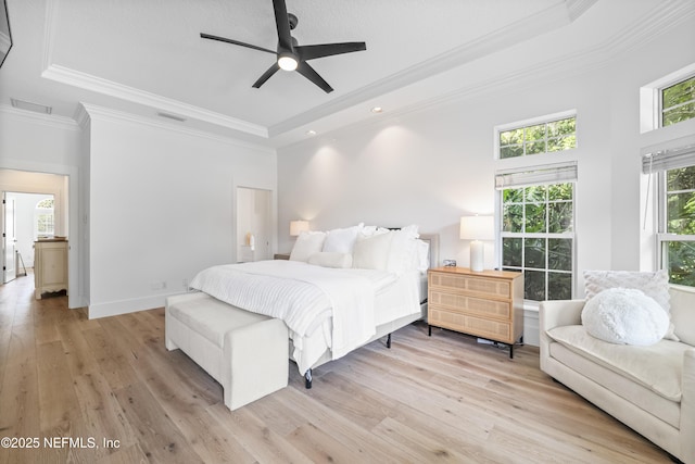 bedroom featuring a tray ceiling, visible vents, ornamental molding, and light wood-style floors