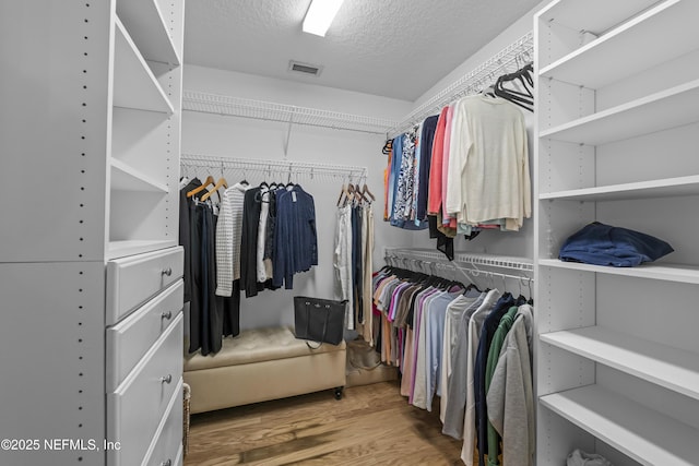 walk in closet with wood finished floors and visible vents
