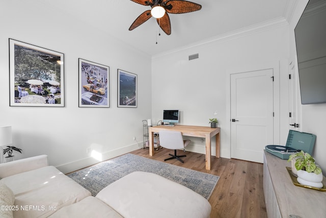 home office with visible vents, a ceiling fan, wood finished floors, and ornamental molding