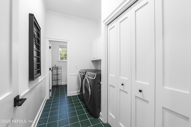laundry area with cabinet space, dark tile patterned flooring, crown molding, and washer and clothes dryer