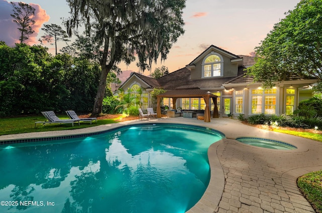 pool with an in ground hot tub, a patio, and a gazebo