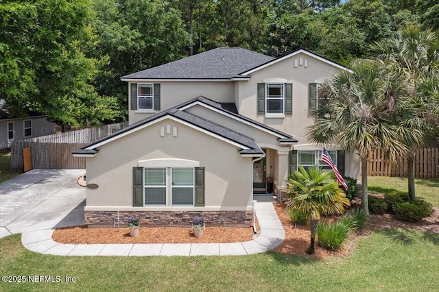 traditional-style home with stone siding, stucco siding, fence, a shingled roof, and a front yard