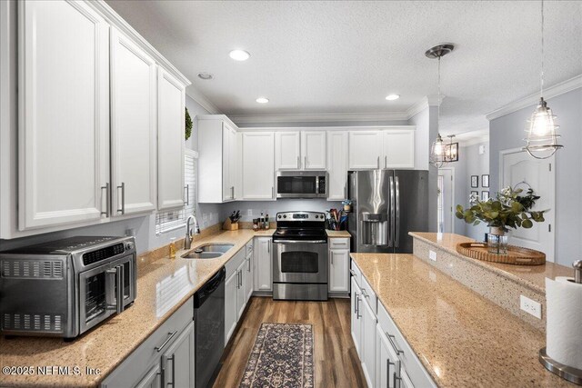 kitchen featuring a sink, crown molding, stainless steel appliances, and white cabinets
