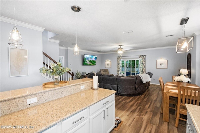 kitchen featuring crown molding, white cabinetry, a ceiling fan, and dark wood finished floors