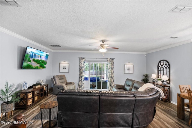 living room featuring a textured ceiling, visible vents, wood finished floors, and ceiling fan