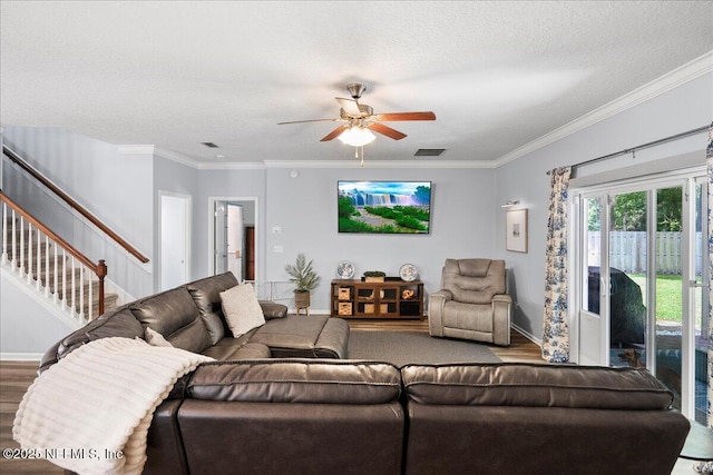 living area with baseboards, ornamental molding, ceiling fan, stairs, and wood finished floors