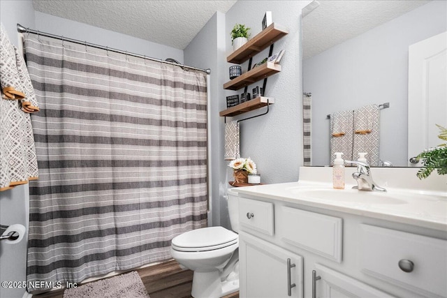 full bath featuring toilet, wood finished floors, a shower with curtain, a textured ceiling, and vanity