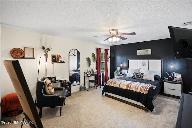 carpeted bedroom with a ceiling fan, visible vents, and a textured ceiling