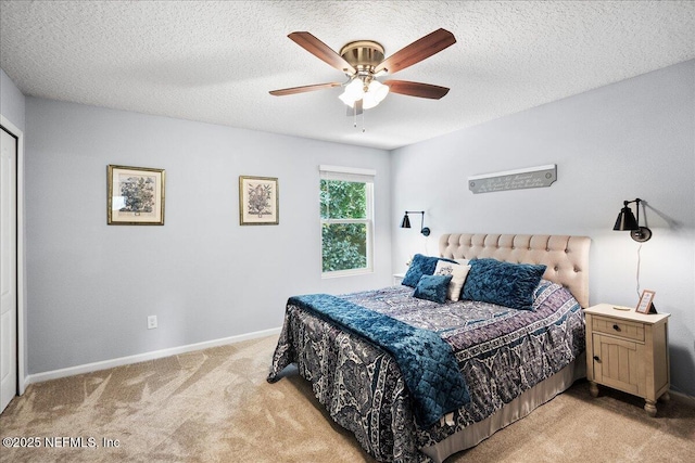 bedroom featuring a textured ceiling, light carpet, baseboards, and ceiling fan
