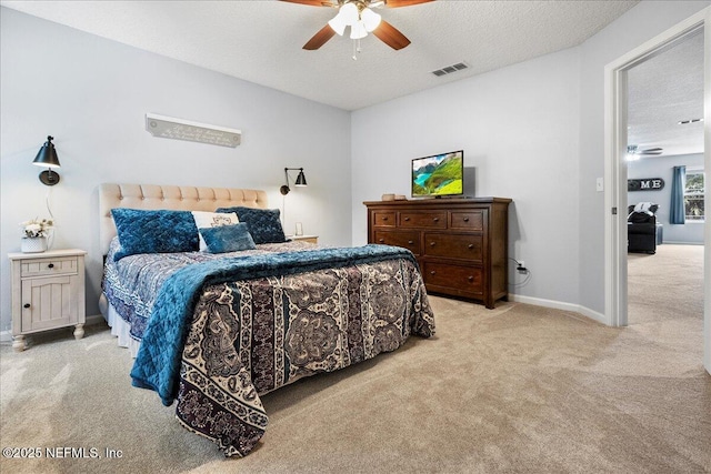 bedroom featuring baseboards, light carpet, visible vents, and a textured ceiling