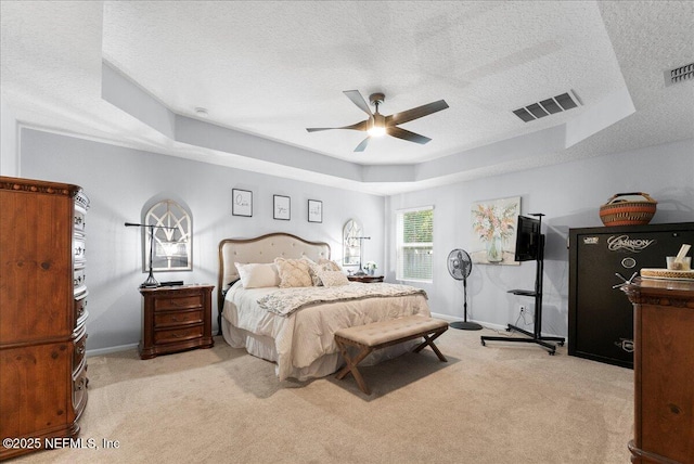 bedroom featuring a raised ceiling, carpet, a textured ceiling, and visible vents