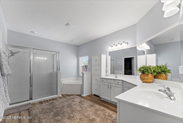 full bath featuring a stall shower, vanity, a bath, and wood finished floors
