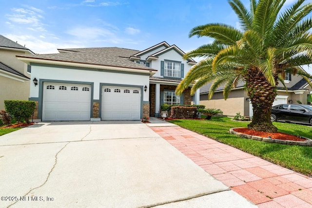 3753 Old Hickory Ln, Orange Park, FL 32065 - view of front of property featuring a garage, a front yard, roof with shingles, stucco siding, and concrete driveway