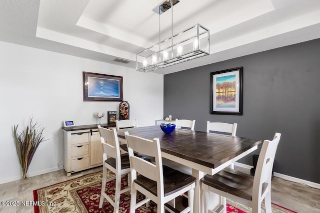 3753 Old Hickory Ln, Orange Park, FL 32065 - dining room featuring a chandelier, baseboards, visible vents, and a raised ceiling