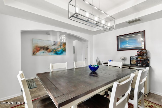 3753 Old Hickory Ln, Orange Park, FL 32065 - dining area with visible vents, arched walkways, wood finished floors, baseboards, and an inviting chandelier