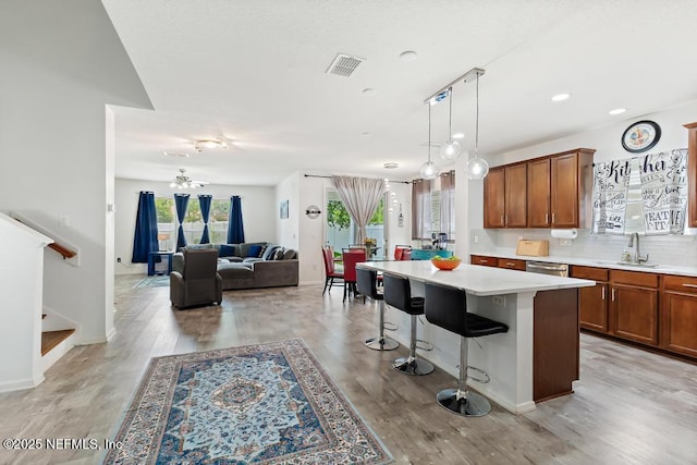 3753 Old Hickory Ln, Orange Park, FL 32065 - kitchen with visible vents, brown cabinetry, a kitchen breakfast bar, light countertops, and a sink