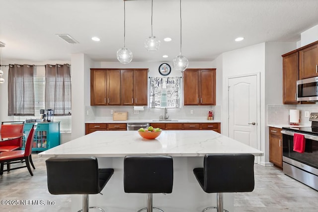 3753 Old Hickory Ln, Orange Park, FL 32065 - kitchen featuring a breakfast bar, tasteful backsplash, a sink, appliances with stainless steel finishes, and hanging light fixtures