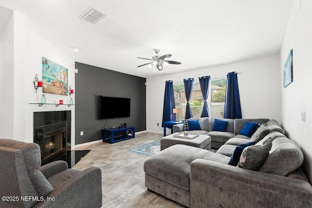3753 Old Hickory Ln, Orange Park, FL 32065 - living room featuring ceiling fan, a textured ceiling, light wood-style flooring, baseboards, and visible vents