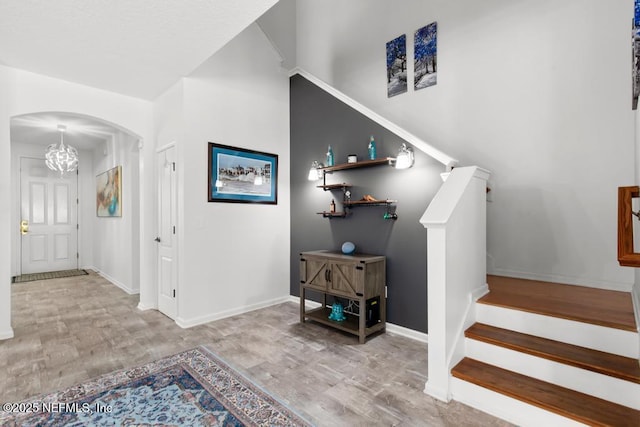 3753 Old Hickory Ln, Orange Park, FL 32065 - foyer entrance featuring baseboards, arched walkways, wood finished floors, and an inviting chandelier
