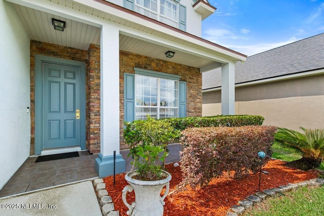 3753 Old Hickory Ln, Orange Park, FL 32065 - doorway to property with covered porch, a shingled roof, and stone siding