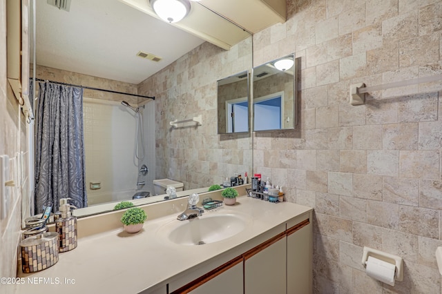 bathroom featuring tile walls, vanity, and shower / bath combination with curtain