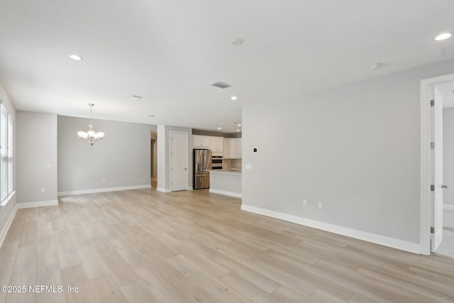 unfurnished living room with recessed lighting, an inviting chandelier, visible vents, and light wood-style floors