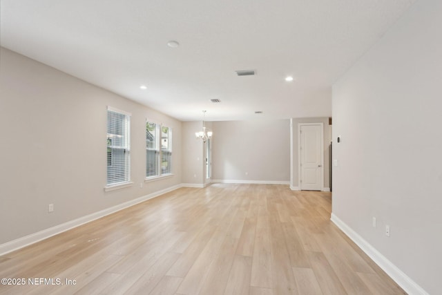 spare room with an inviting chandelier, recessed lighting, visible vents, and light wood-type flooring