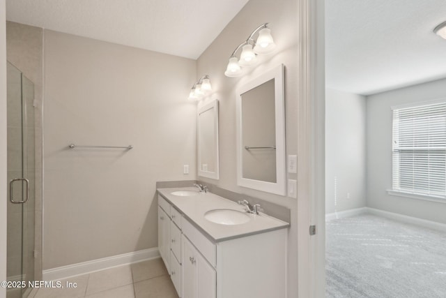 bathroom featuring double vanity, a sink, baseboards, and a shower stall