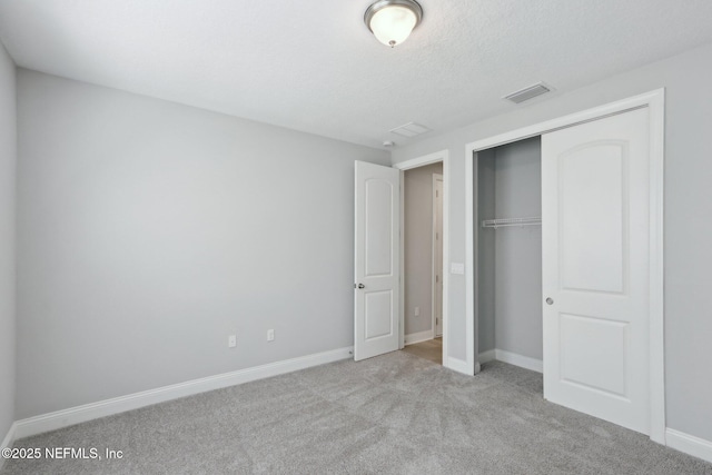 unfurnished bedroom with visible vents, carpet flooring, baseboards, and a closet