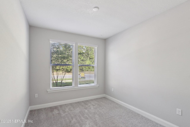 spare room featuring baseboards and carpet
